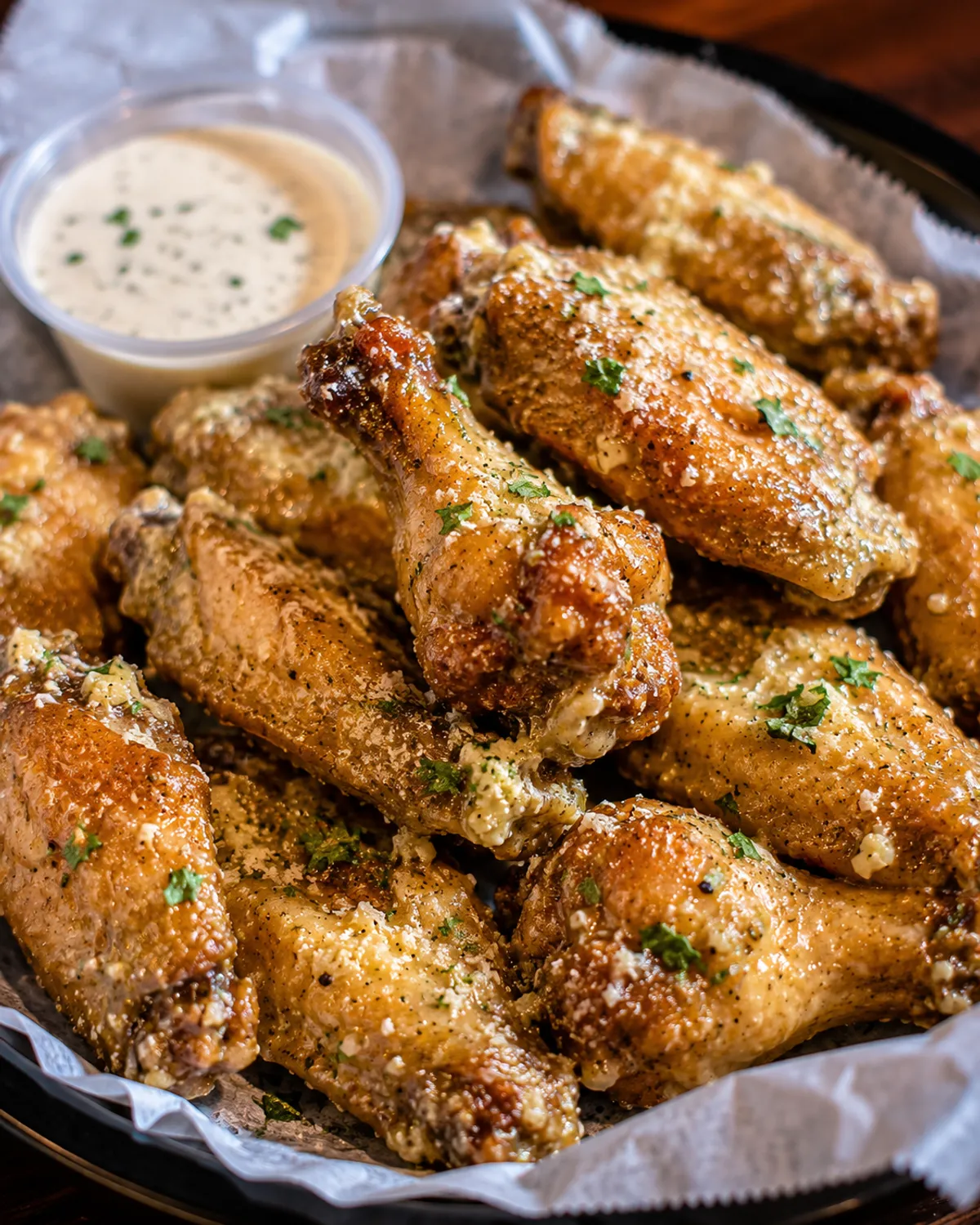 Garlic parmesan wings in a basket with ranch at Buzz City