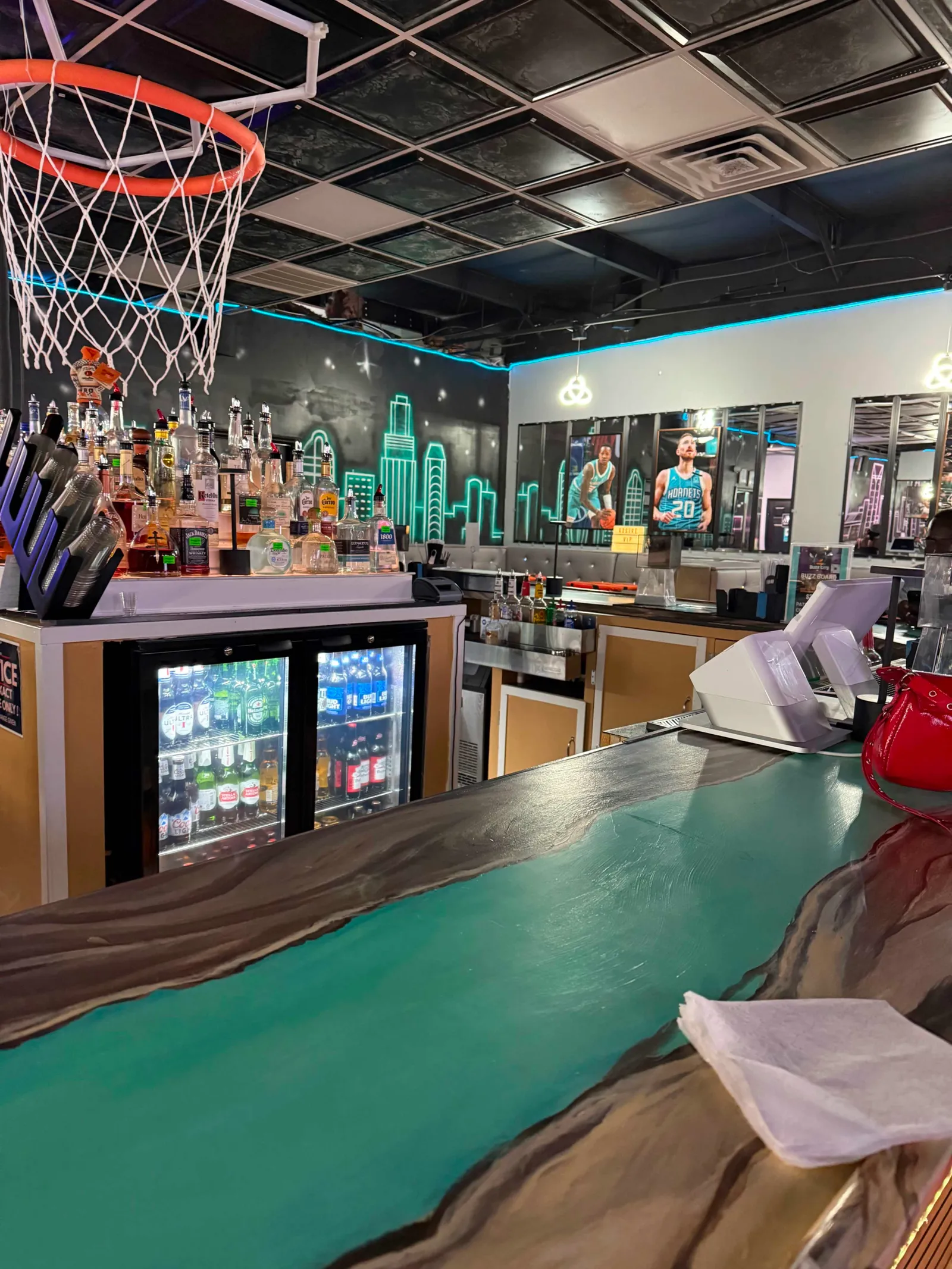 Skyline-mural booths and lounge seating at Buzz City Sports Venue in Charlotte